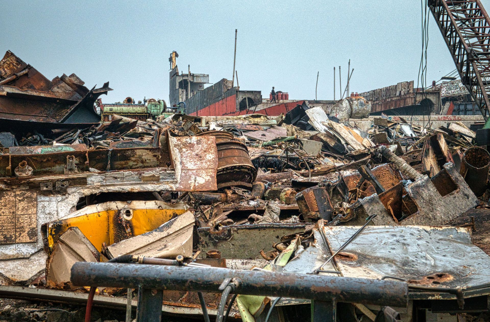 Metal rusty worn out constructions with cargo crane on dump in neglected area